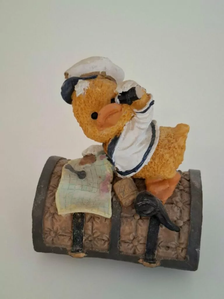 Resin figurina pačić u mornarskome odijelu na brodskom sanduku