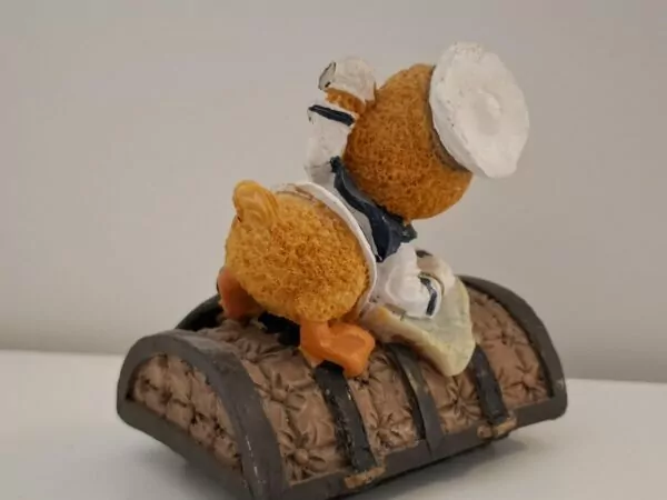 Resin figurina pačić u mornarskome odijelu na brodskom sanduku